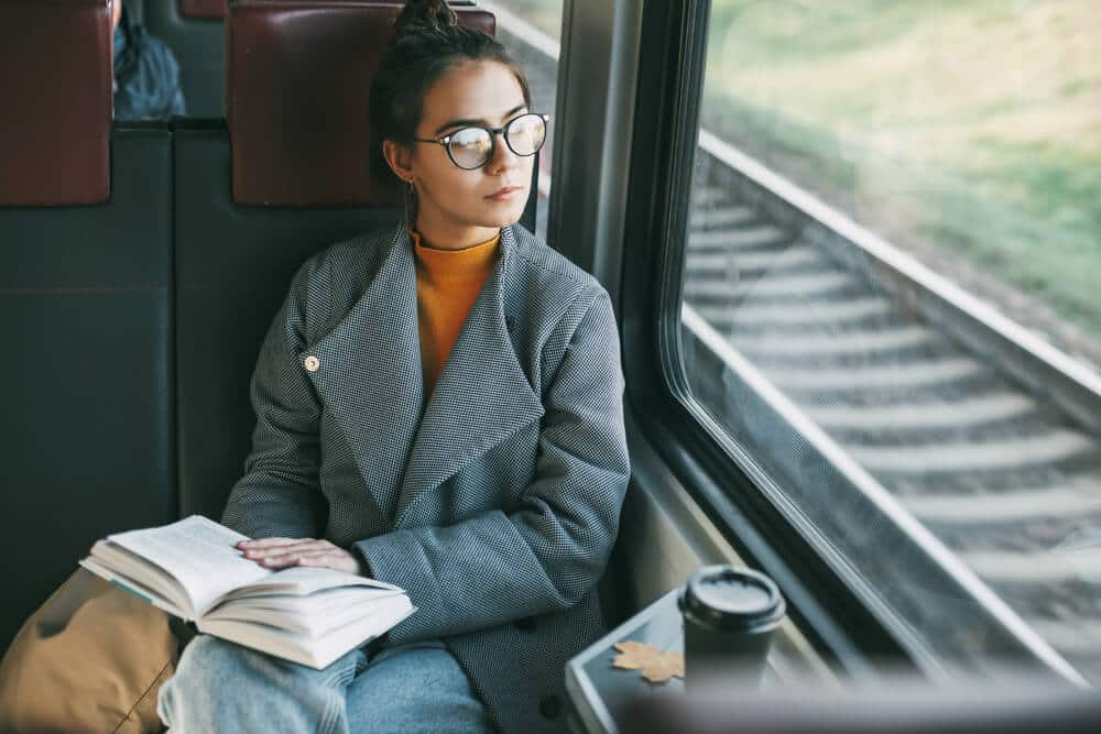 Giovane donna che legge sul treno | www.phillyaptrentals.com