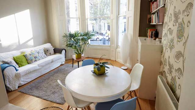 Appartement interieur woonkamer met bank en kleine witte tafel