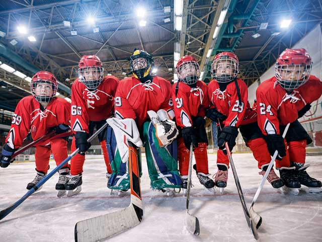 Youth hockey team posing for photo on the ice