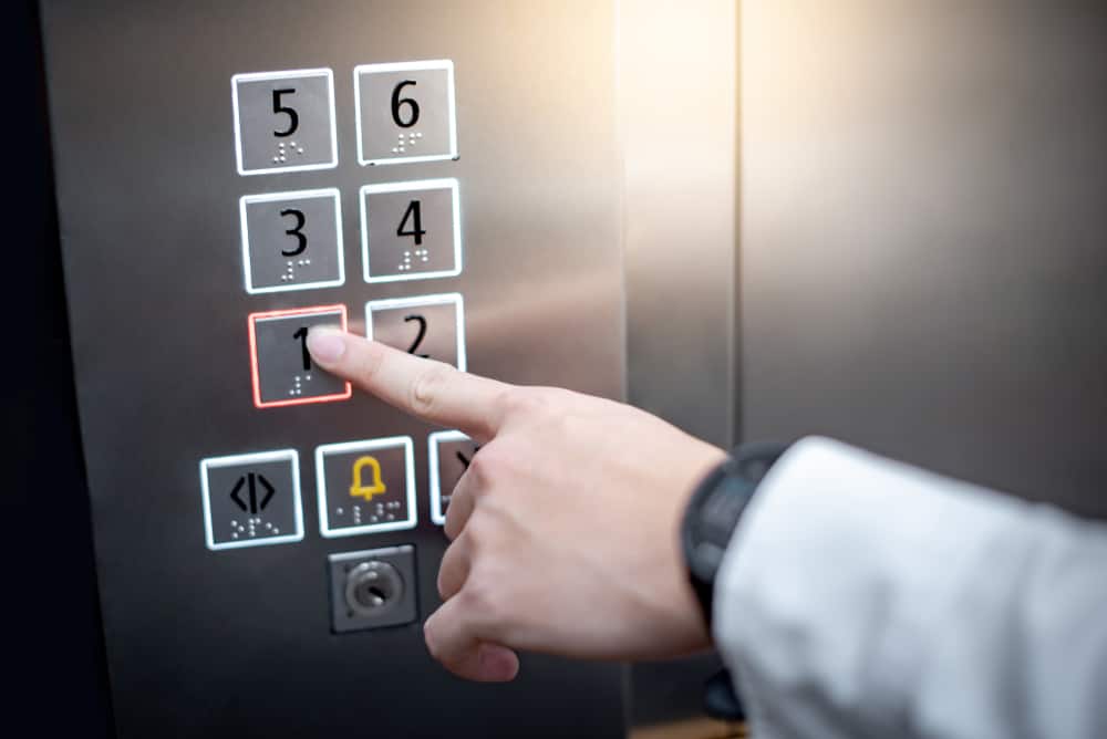 apartamento en el primer piso, hombre haciendo clic en el botón del elevador