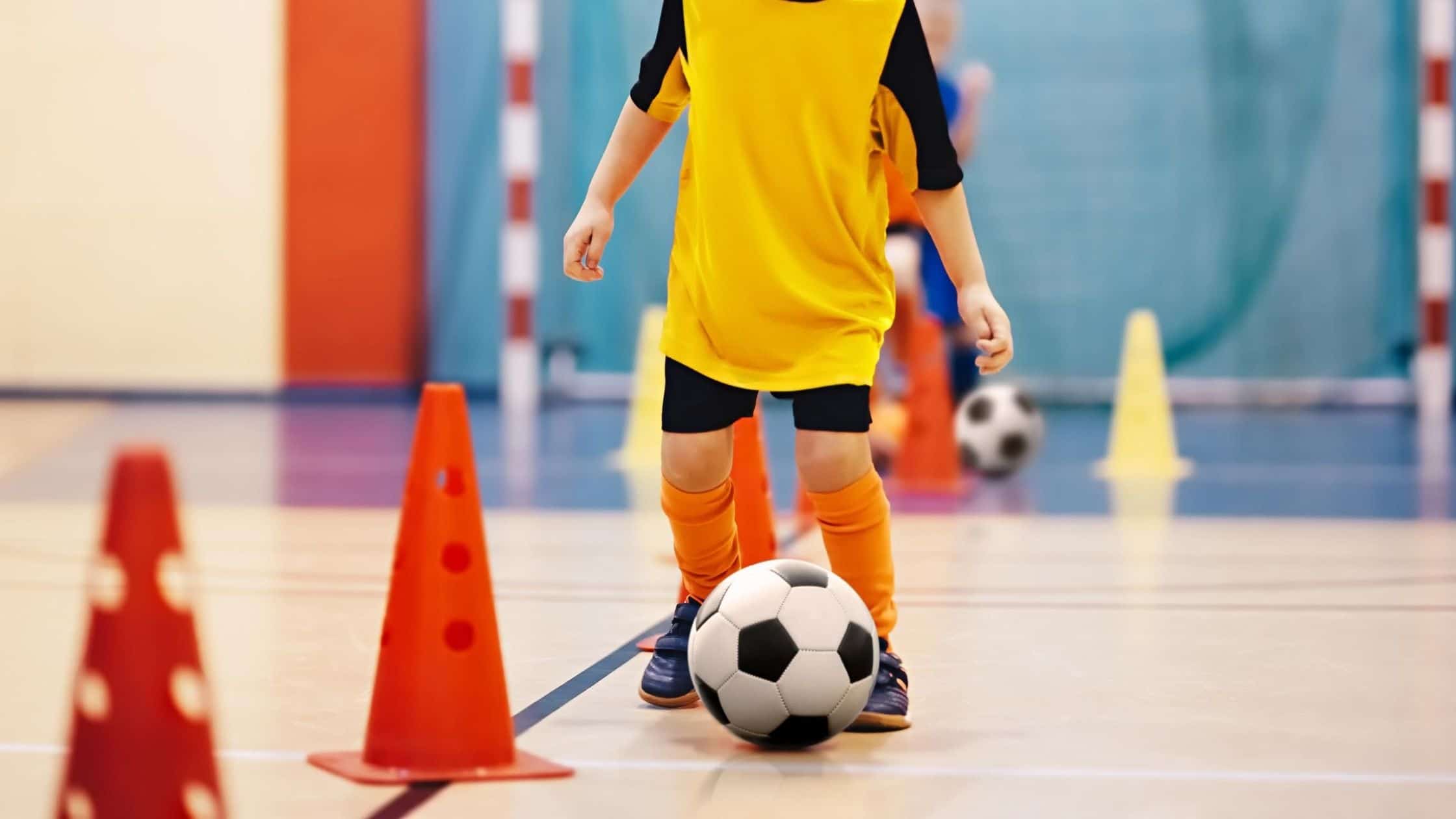 menino jogando futebol