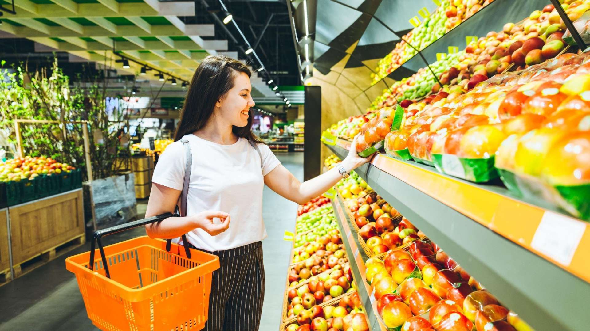 grocery store picture of girl smiling while shopping for fresh produce