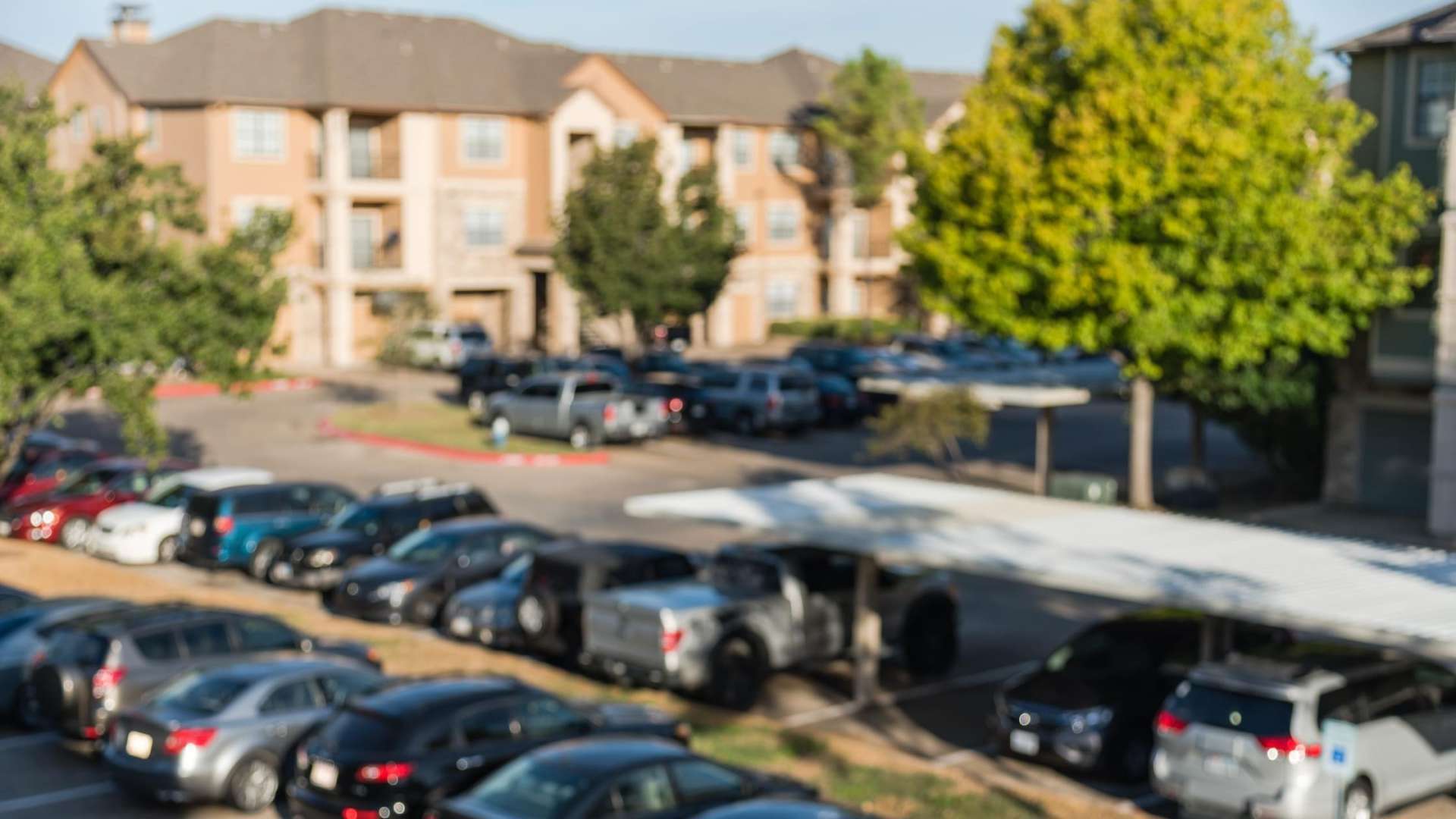 image showing parking and cars in parking spots at apartment complex