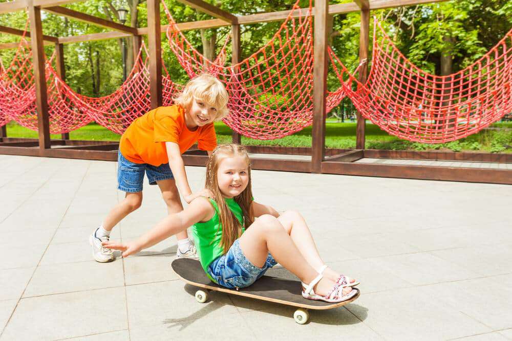 Due bambini sullo skateboard nel parco giochi dell'appartamento | www.phillyaptrentals.com