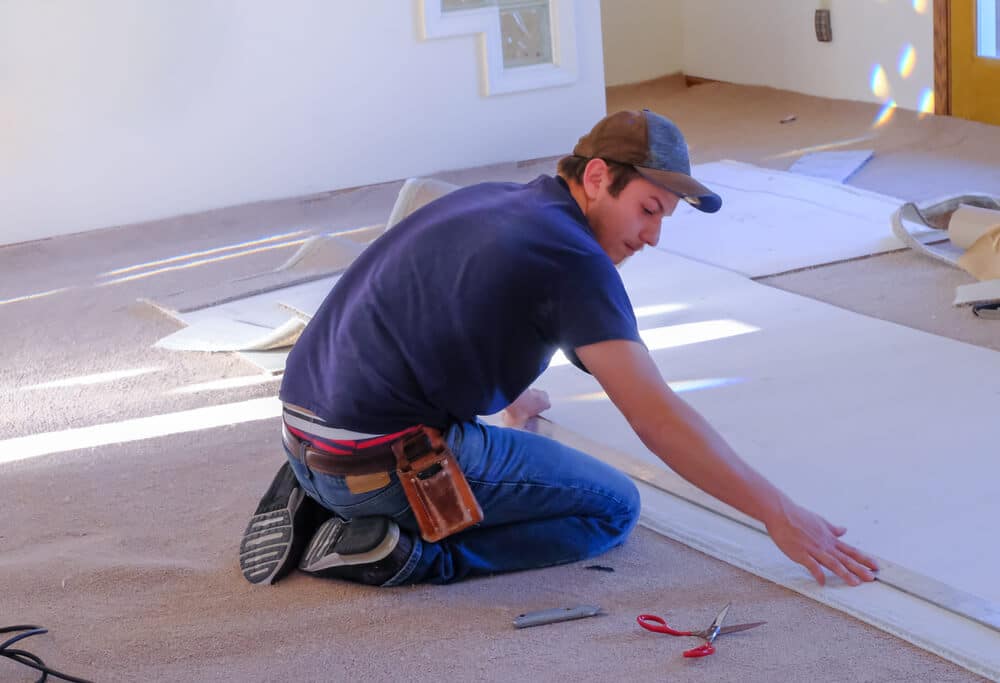 Do Landlords Need To Replace Carpets | Man Laying Carpet | www.phillyaptrentals.com