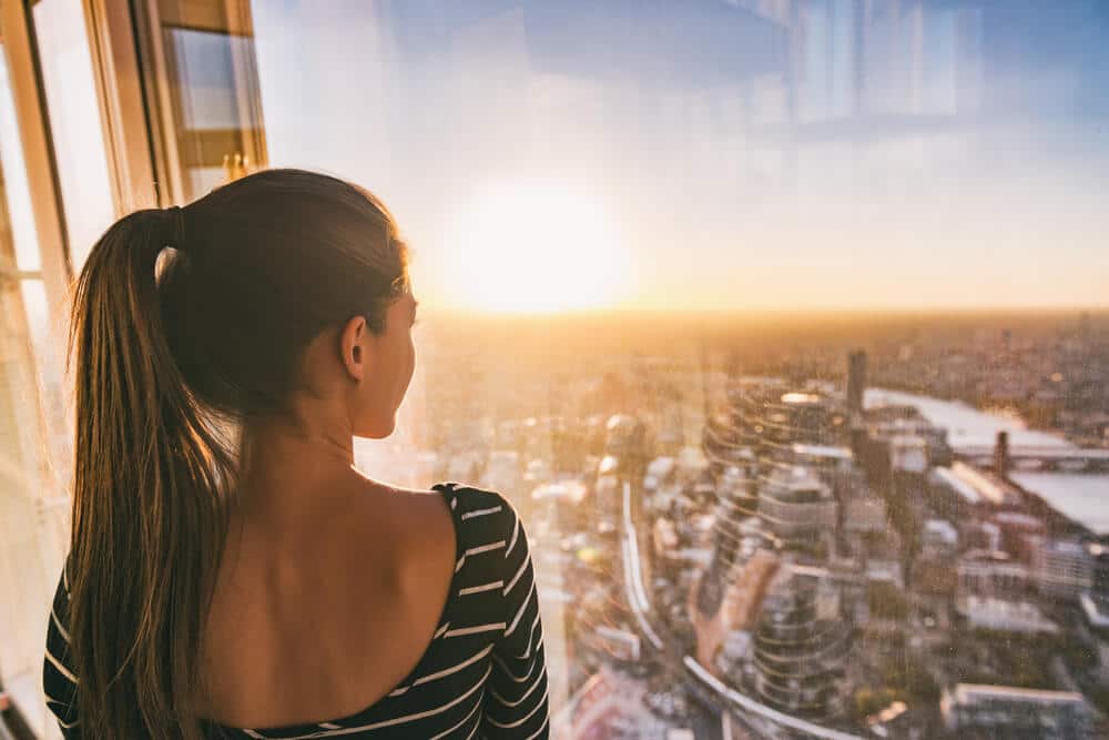 Are Apartments on High Floors More Expensive | Woman Admiring Her View | www.phillyaptrentals.com