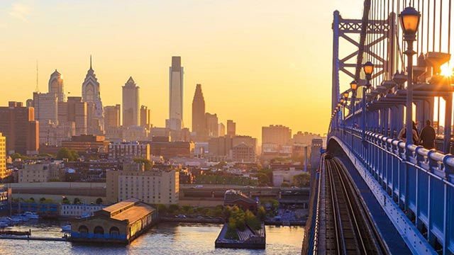 Ben Franklin Bridge prowadzący do Filadelfii o zachodzie słońca