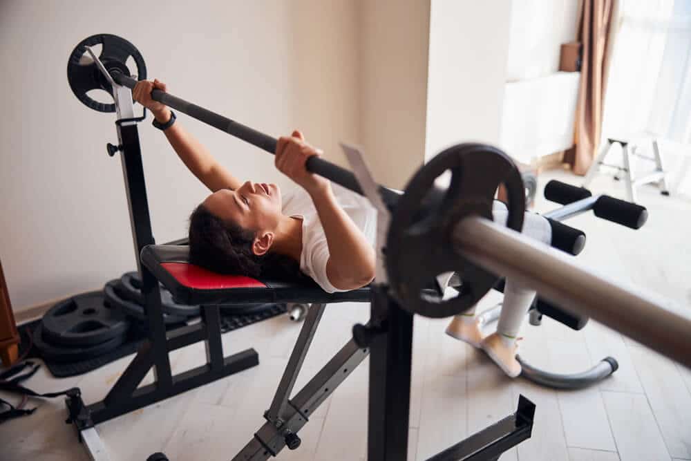 Apartment Weightlifting Equipment | Woman Using Equipment | www.phillyaptrentals.com