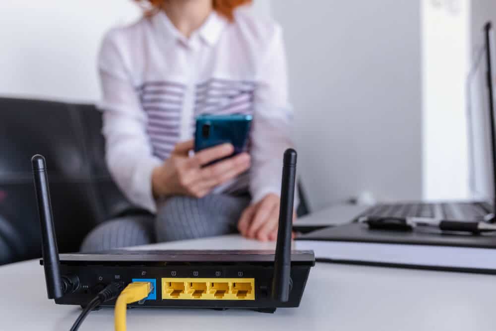 So richten Sie Apartment-WLAN ein | Frau verbindet Router