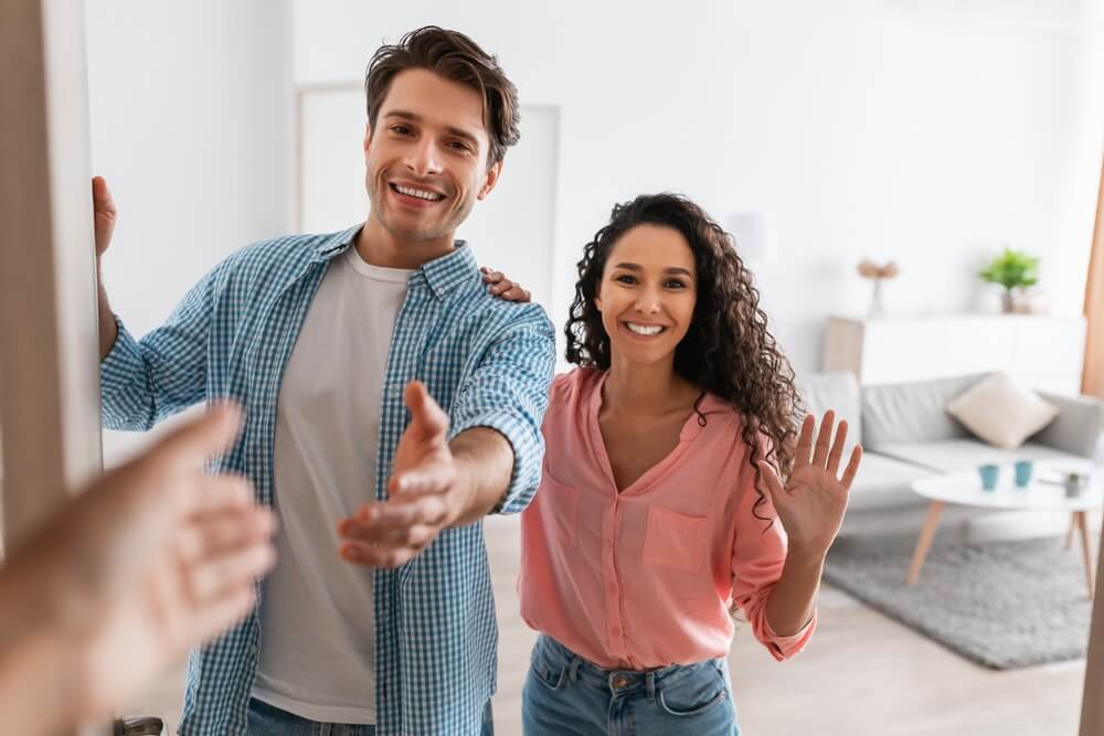 Comment être un voisin respectueux | Couple saluant son voisin à la porte | www.phillyaptrentals.com