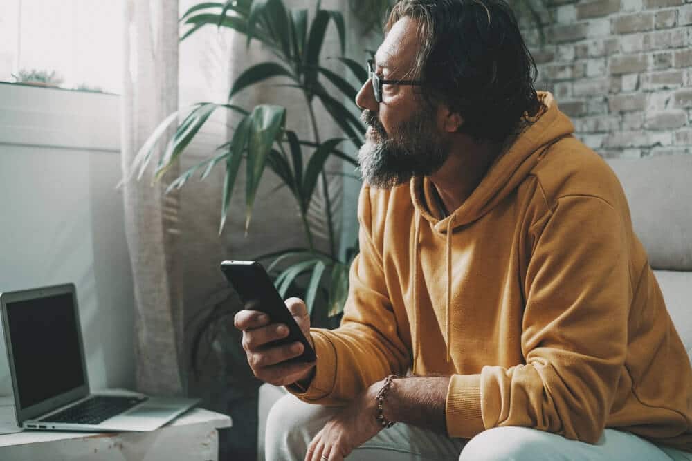 Man Looking at Phone Considering Monthly Expenses | www.phillyaptrentals.com 